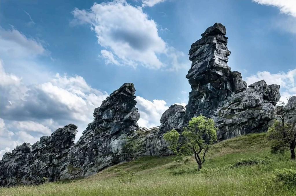 Teufelsmauer im Harz bei Neinstedt mit markanten Sandsteinfelsen, Wiese und blauem Himmel