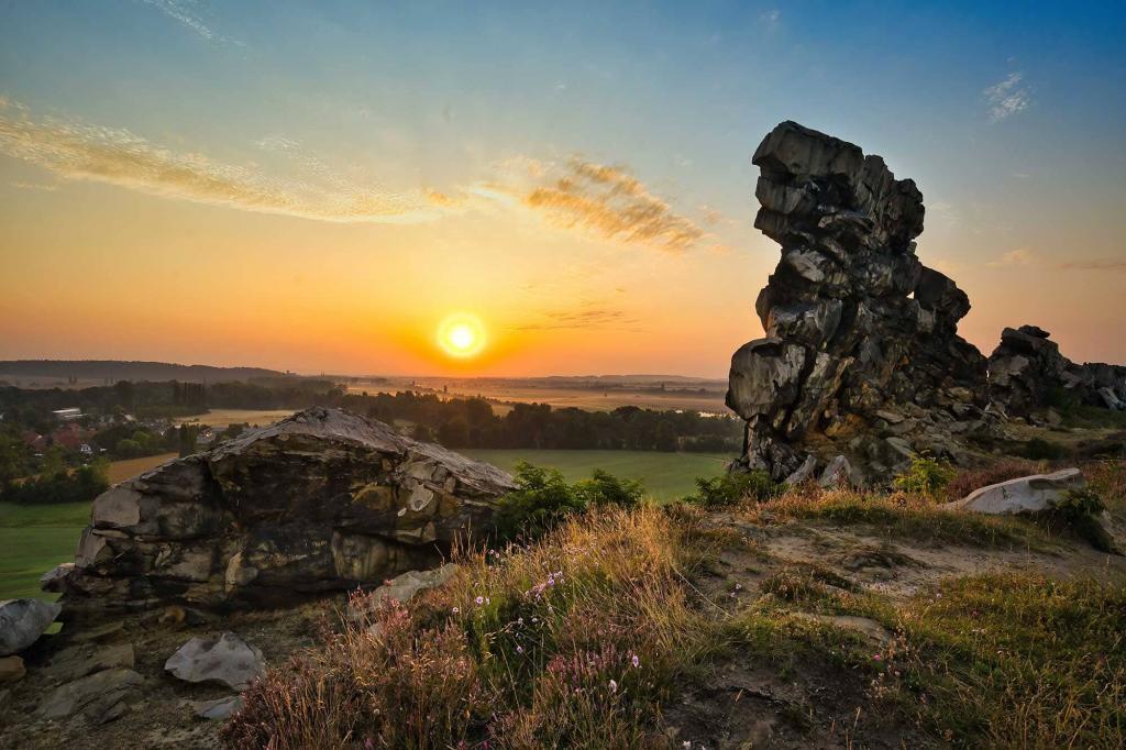 Teufelsmauer im Harz bei Sonnenaufgang mit Sandsteinfelsen, tief stehender Sonne und Blick über die Landschaft